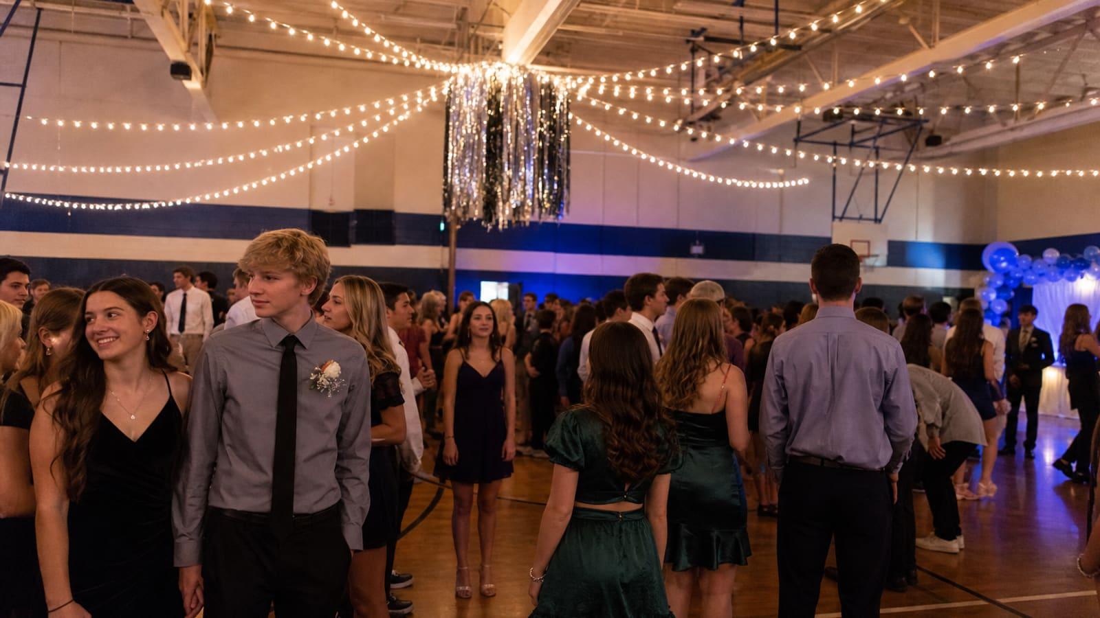 Students and families at a school dance in a gymnasium